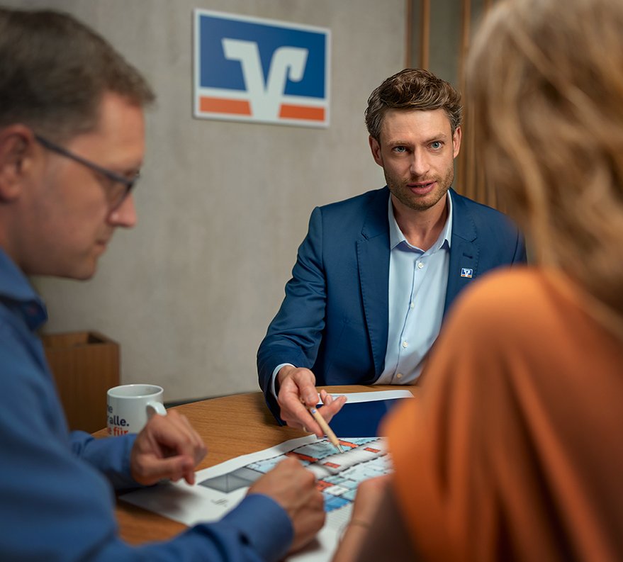 Mann und Frau in einer Produktionshalle vor einer Fertigungsmaschine