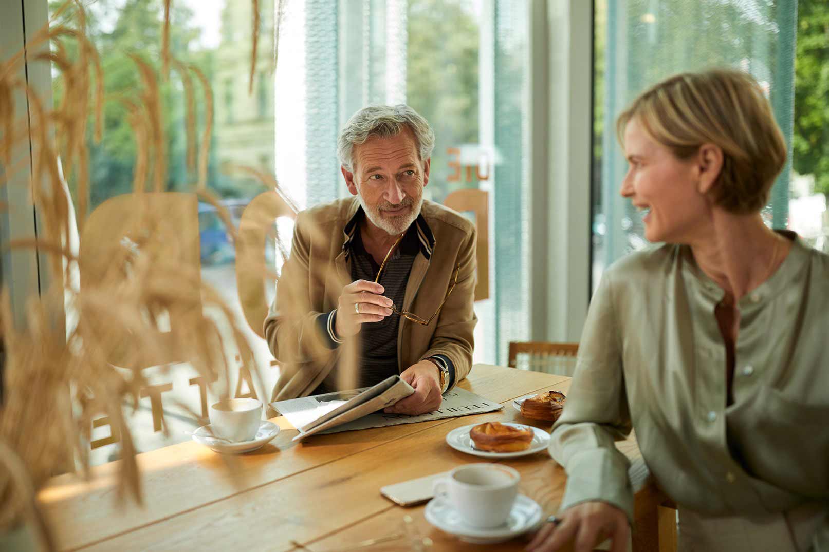 Ein älteres Ehepaar sitzt am Frühstückstisch und unterhält sich über ihre Immobilien